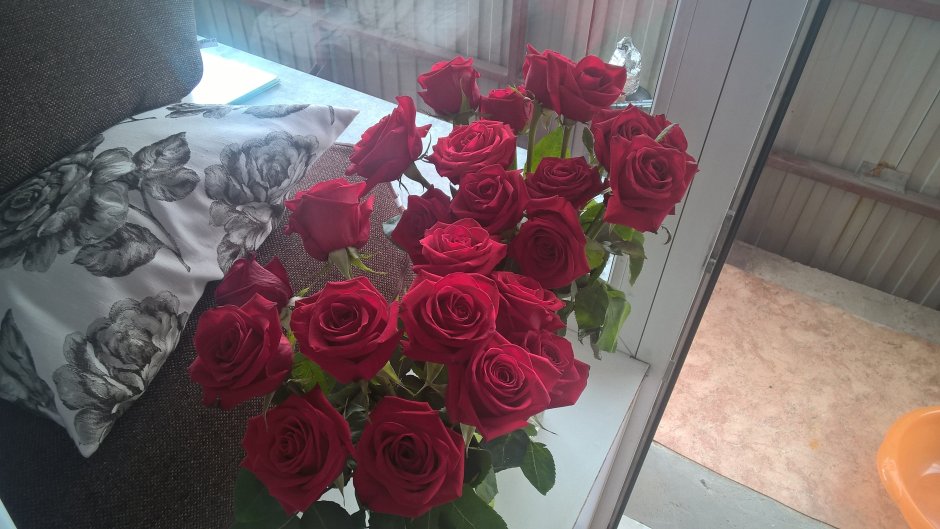 Букет красных роз на подоконнике