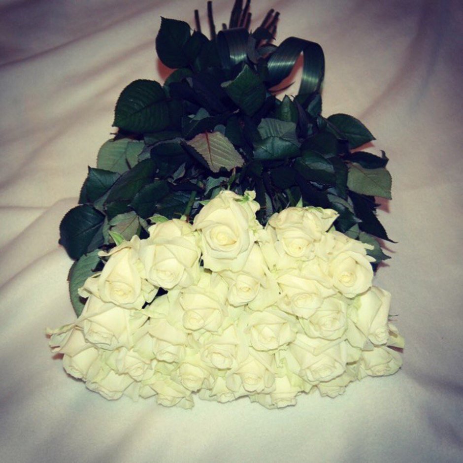 Букет белых роз на кровати