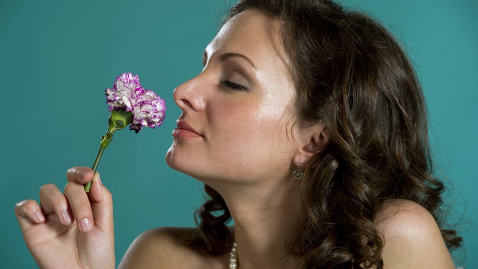 Женщина нюхает цветы