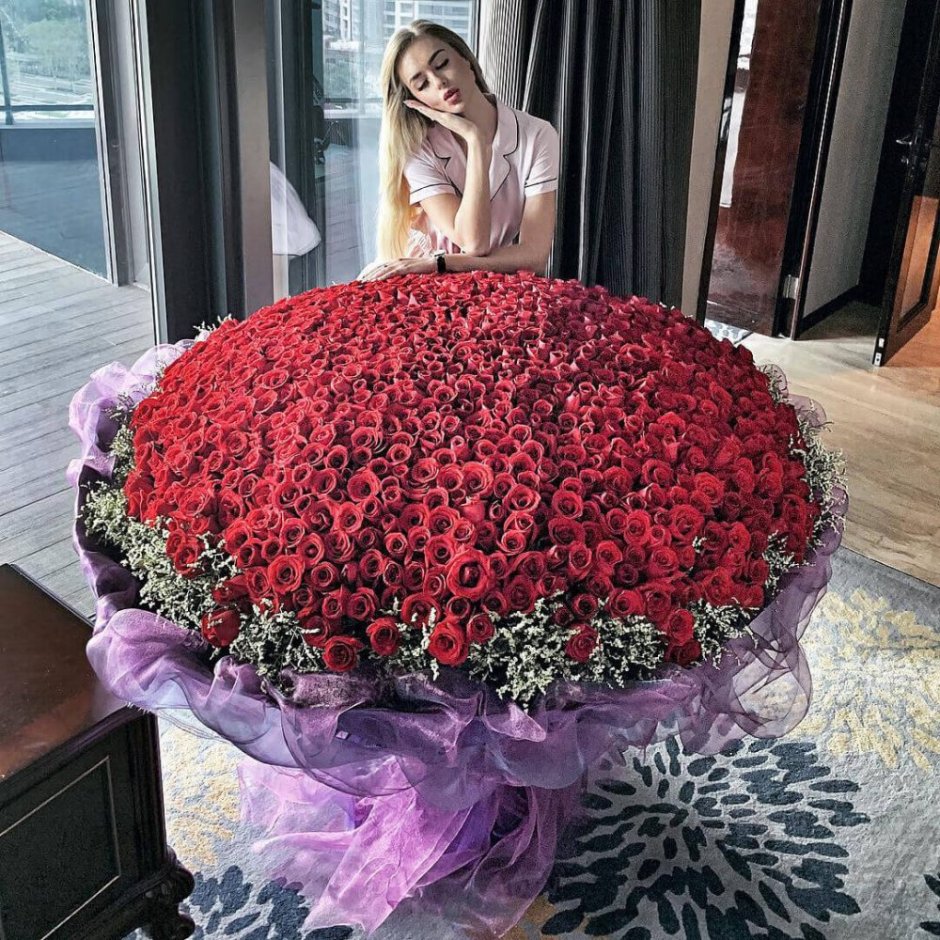 Большой букет красных роз на кровати