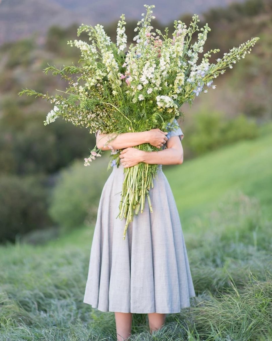 Девушка с охапкой полевых цветов