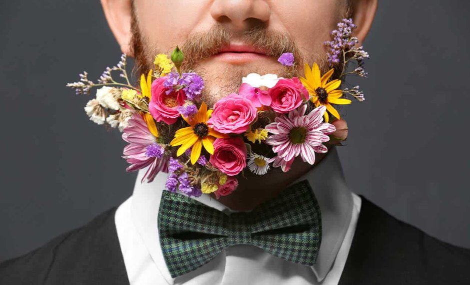 Мужчина с бородой держит цветок