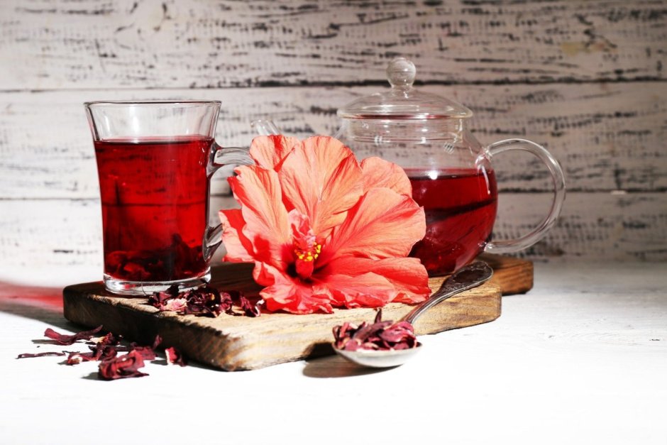 Красный чай в чашке с цветком каркаде