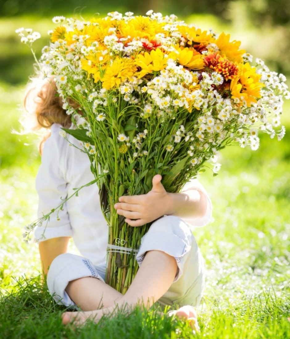 Ребенок с охапкой цветов