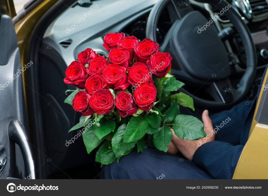 Мужчина с цветами в машине